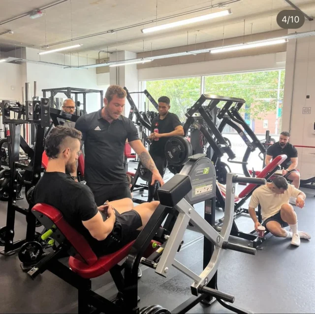 Luke mentoring biomechanics on a leg extension machine