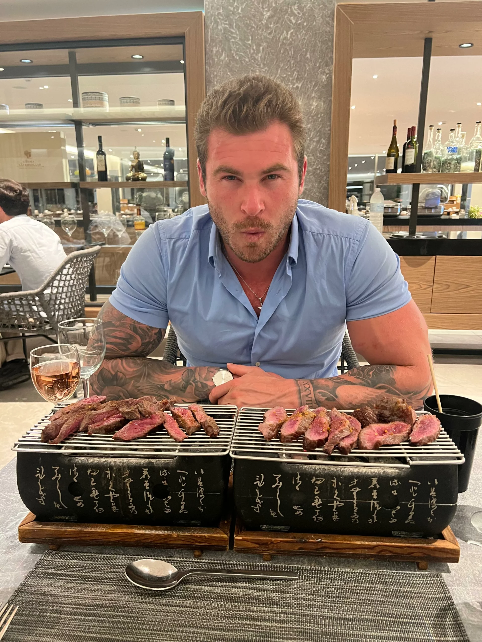 Luke cooking meat at a restaurant at a Korean BBQ