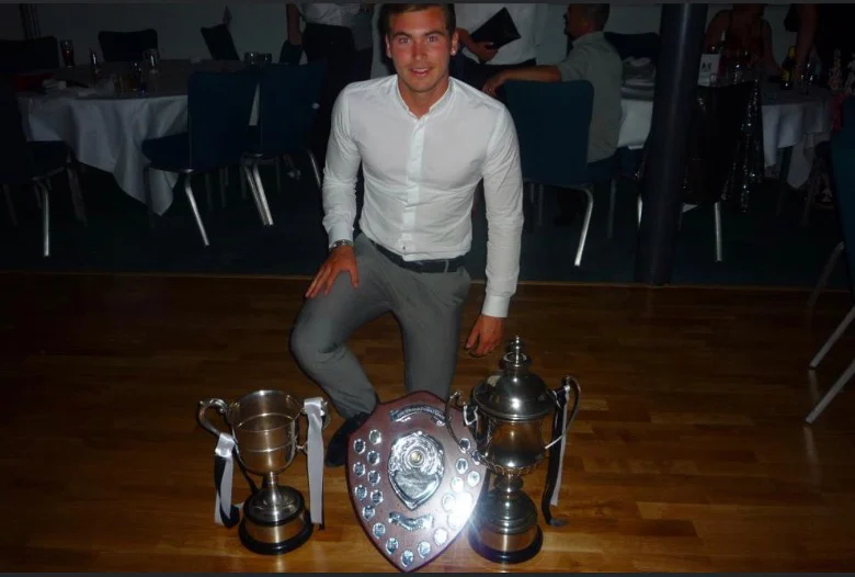 Luke with football trophies